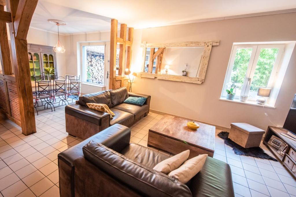 a living room with two couches and a table at le clos du puits in Maslives