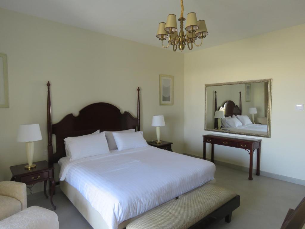 a bedroom with a large white bed and a mirror at Holiday Home 3 bedroom Seaview in Ras al Khaimah