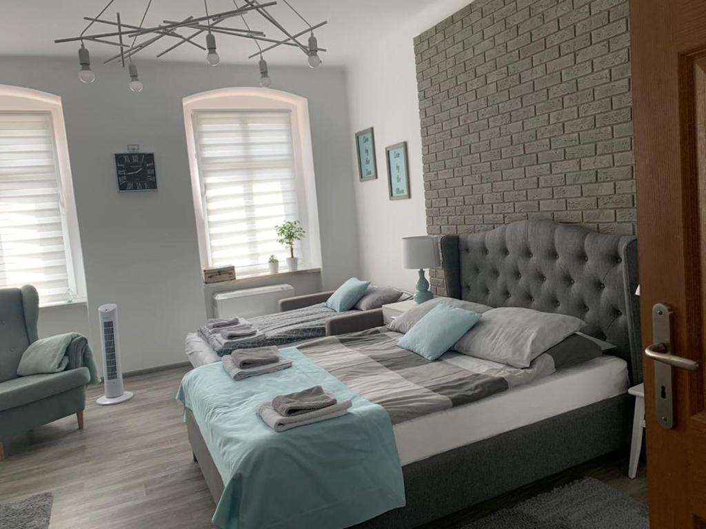 1 dormitorio con 1 cama grande y pared de ladrillo en Mięta Opole, en Opole