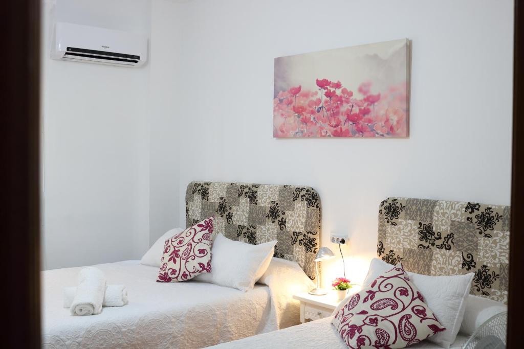 a bedroom with two beds and two chairs at Granada City Center in Granada