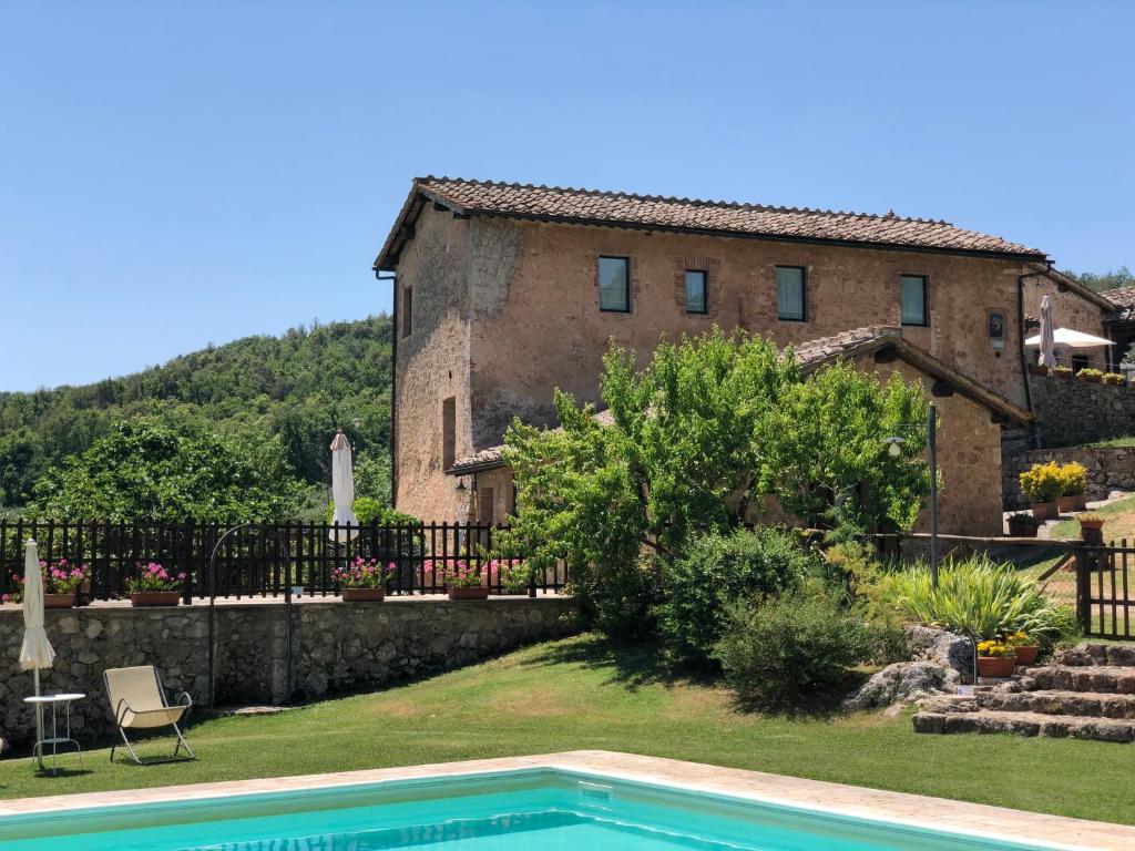a house and a swimming pool in front of a house at Agriturismo Il Caggio in Sovicille
