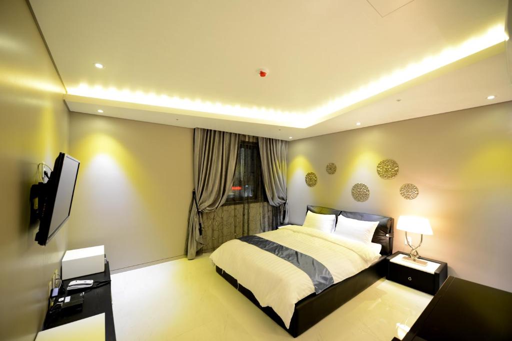 Postel nebo postele na pokoji v ubytování Dunsan Graytone Hotel