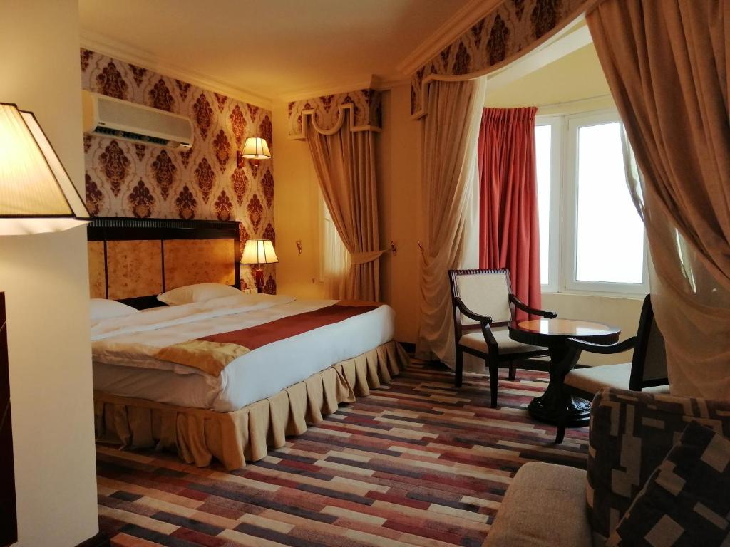 a hotel room with a bed and a table at Dmas Hotel in Muscat