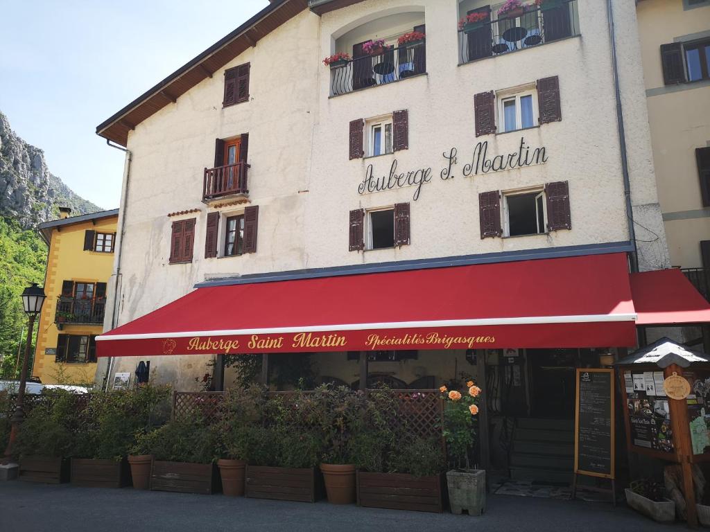 a building with a red awning in front of it at Auberge Saint Martin in La Brigue