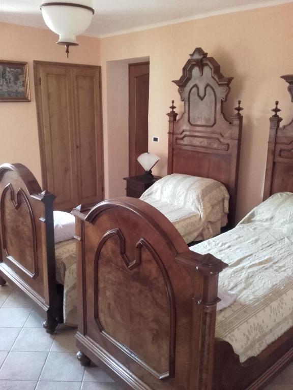 a bedroom with two beds and a large headboard at Agriturismo Doremi in Vignolo