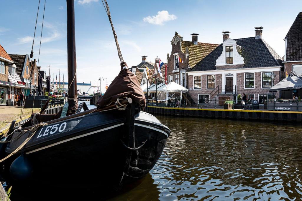 un barco está atracado en un canal en una ciudad en Bed & Breakfast Easy to Sleep, en Lemmer