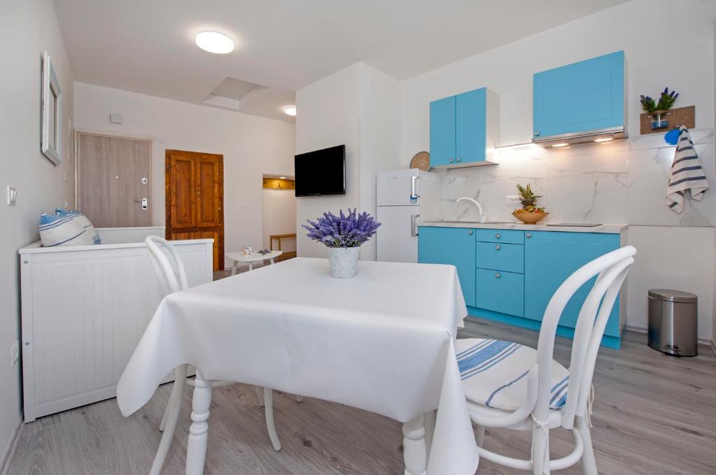 uma cozinha e sala de jantar com uma mesa branca e cadeiras em Apartment Babbo em Rovinj