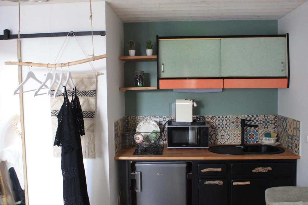uma cozinha com um balcão e um micro-ondas em COUP DE COEUR Studio em Rivedoux-Plage