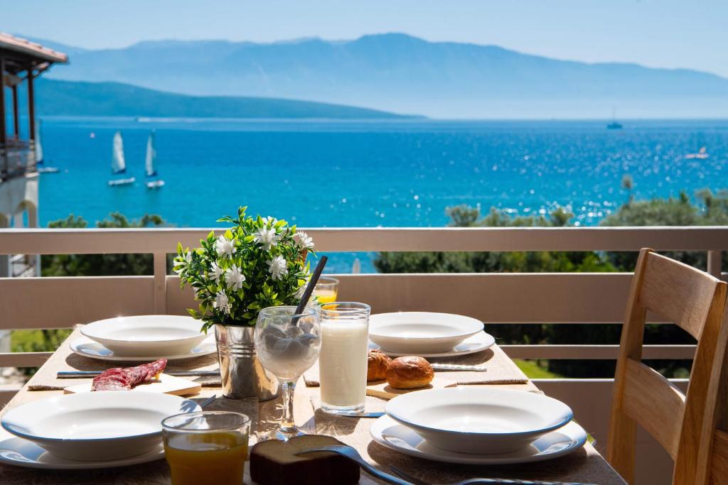uma mesa com pratos de comida e vista para o oceano em Ifi Sea House em Nikiana