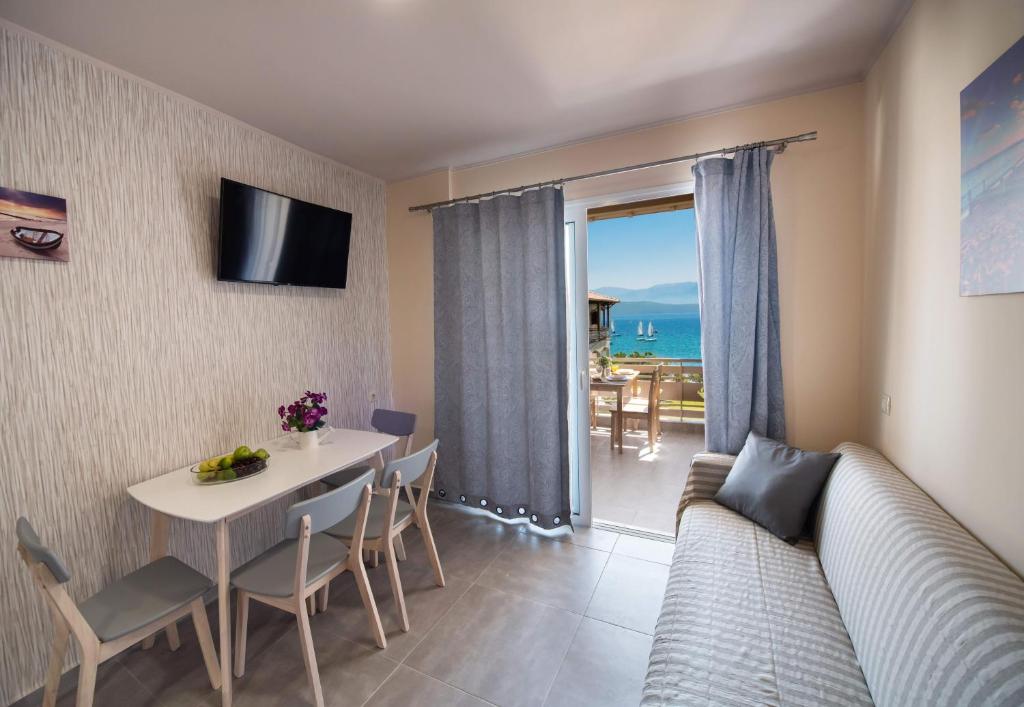 salon z kanapą i stołem z krzesłami w obiekcie Ifi Sea House w mieście Nikiana