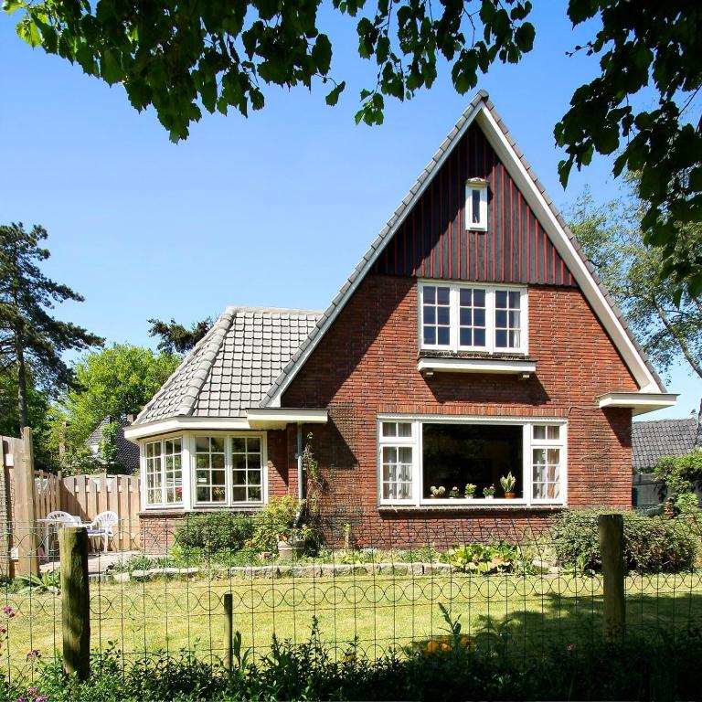a red brick house with a gambrel roof at De Sloep in Bergen