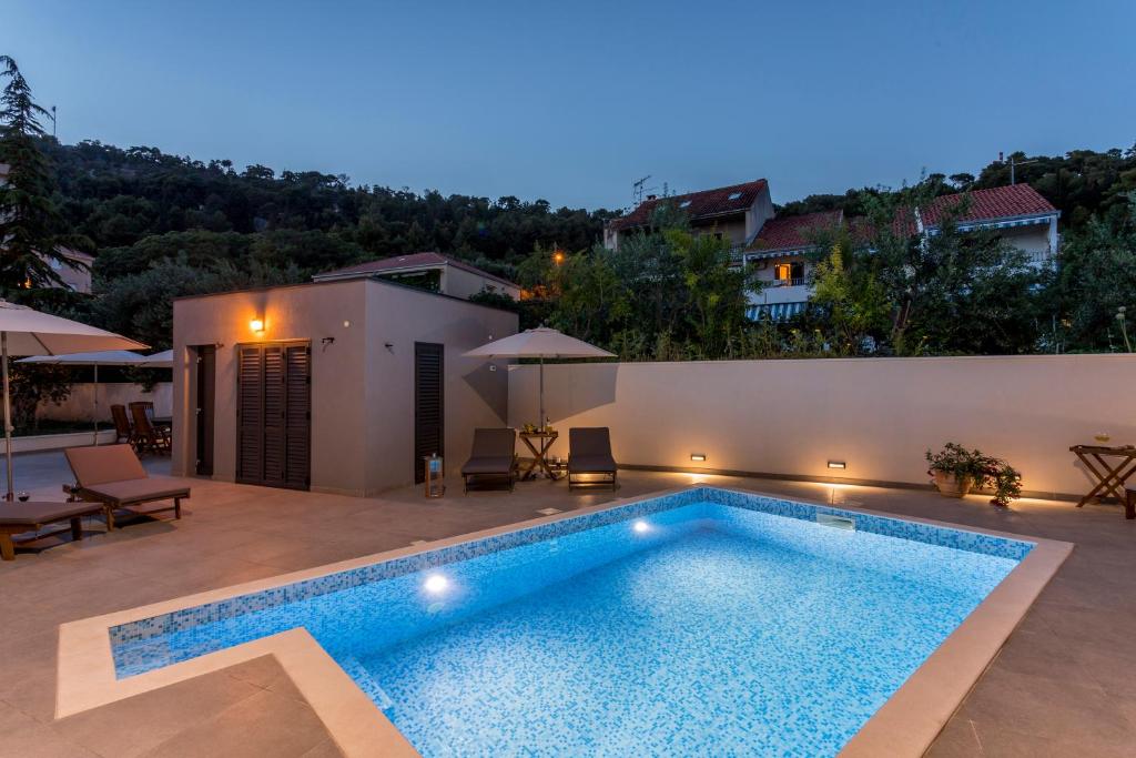 eine Villa mit einem Pool in der Nacht in der Unterkunft 2NIGHTSTUDIOS in Split