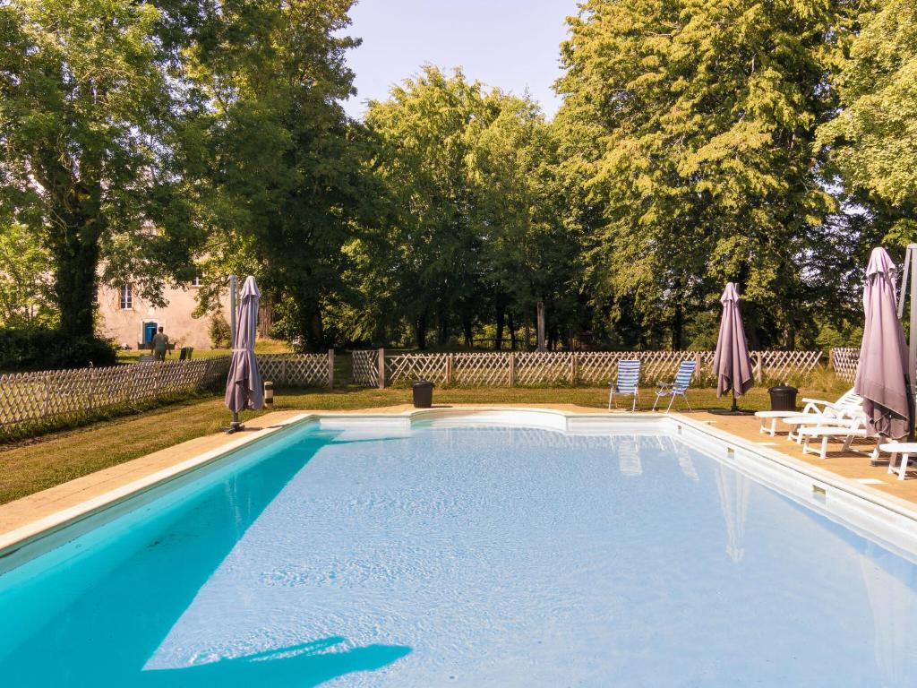 a swimming pool with two lawn chairs and umbrellas at Heritage Castle in Chaleix with shared pool in Chaleix