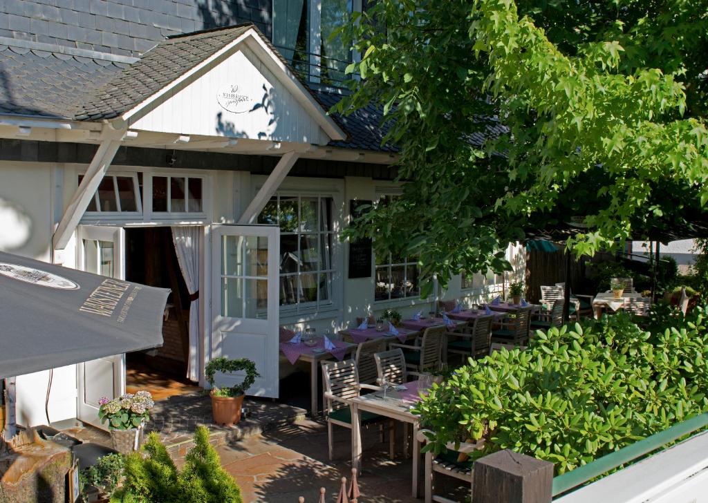 a restaurant with tables and chairs in front of a building at Hotel-Restaurant Schettel in Olsberg