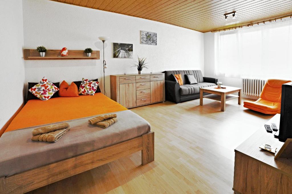 - une chambre avec un grand lit et un salon dans l'établissement apartmány 2+1 u Klínovce, à Kovářská