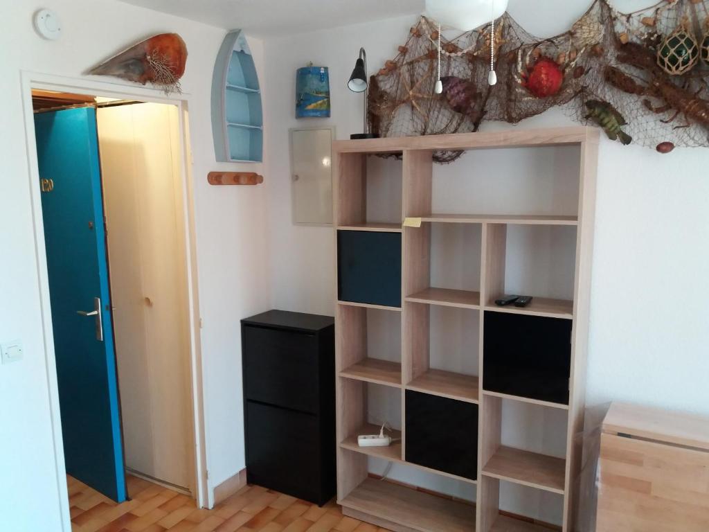 Zimmer mit offenen Regalen und einer Tür in der Unterkunft studio Cap D'adge in Cap d'Agde