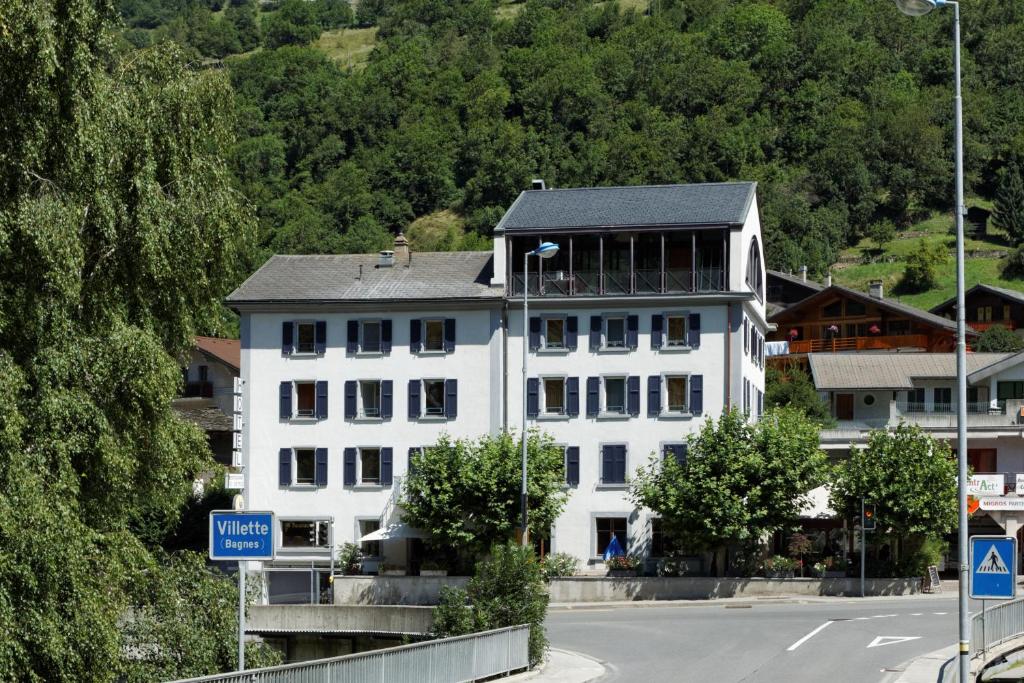 a white building on the side of a road at Hotel Restaurant Le Giétroz in Le Châble