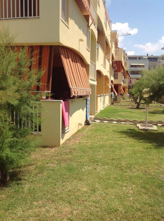 a building with a grass yard next to a building at APPARTAMENTO LIDO 2 in Alghero