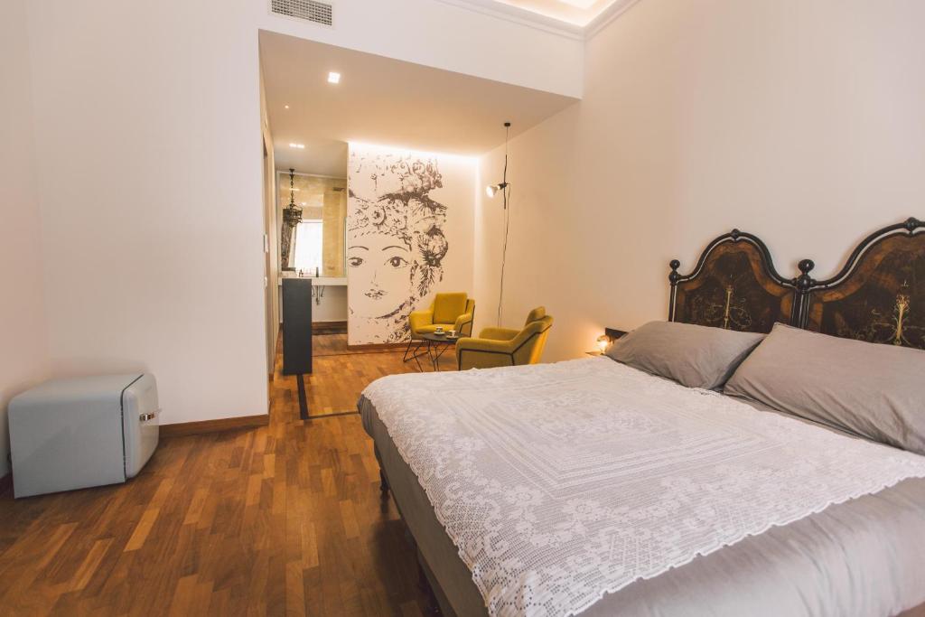 sypialnia z dużym białym łóżkiem i salonem w obiekcie Suites of the Royal Council w Syrakuzach