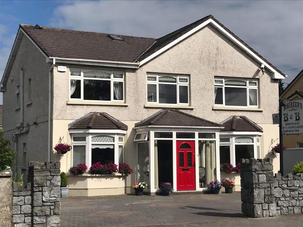 a house with a red door and flowers in front at Maureen's Bed and Breakfast in Tralee