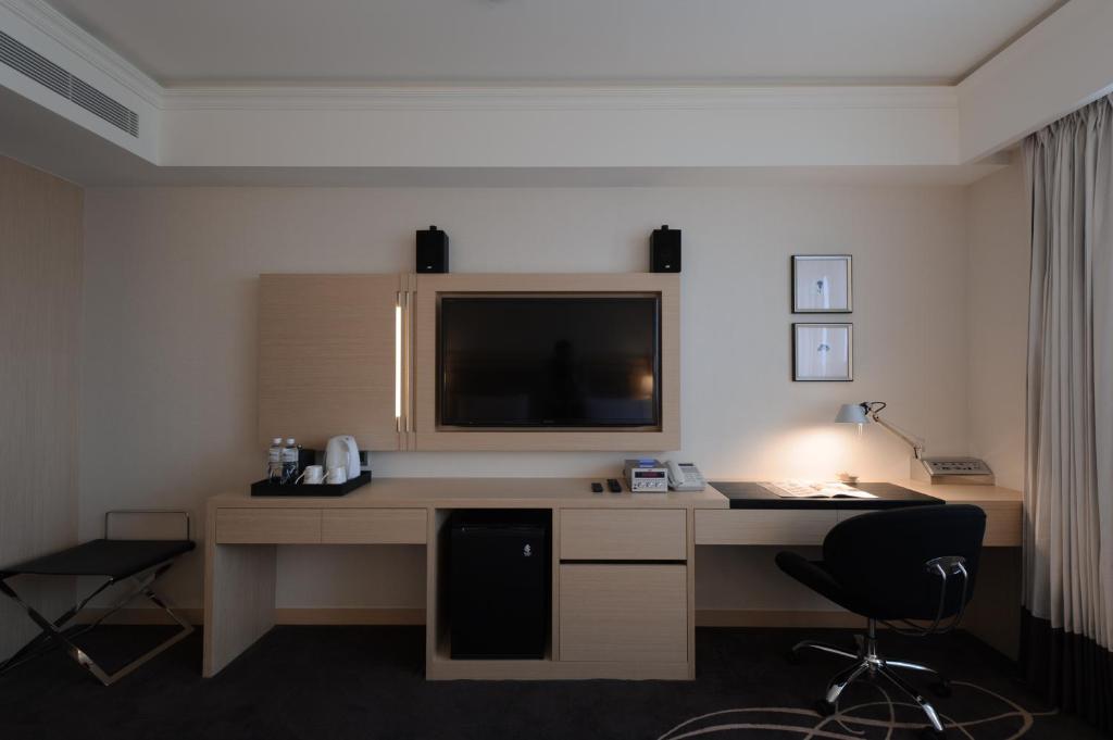 a room with a desk with a monitor and a chair at K Hotel Taipei Songjiang in Taipei