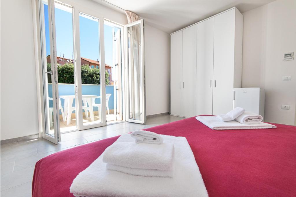 a bedroom with a red bed with towels on it at Residence Marina Salivoli in Piombino