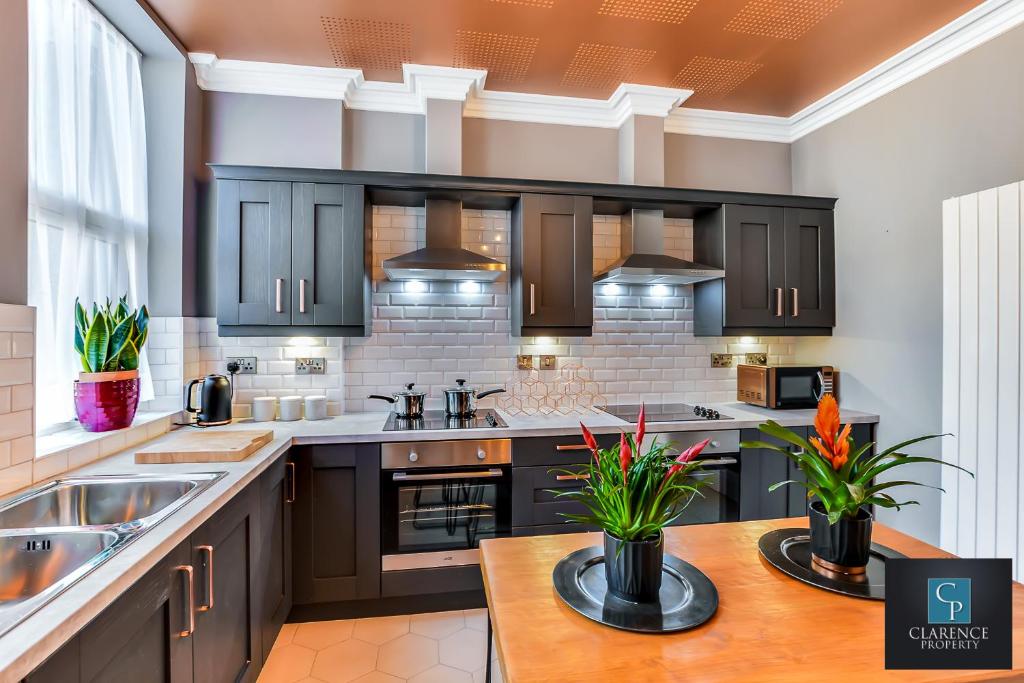 a kitchen with black cabinets and a wooden table at Art House in Derry Londonderry