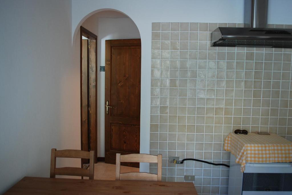 eine Küche mit 2 Stühlen, einem Tisch und einer Tür in der Unterkunft Casa rosa sull'appennino tosco emiliano in Barigazzo