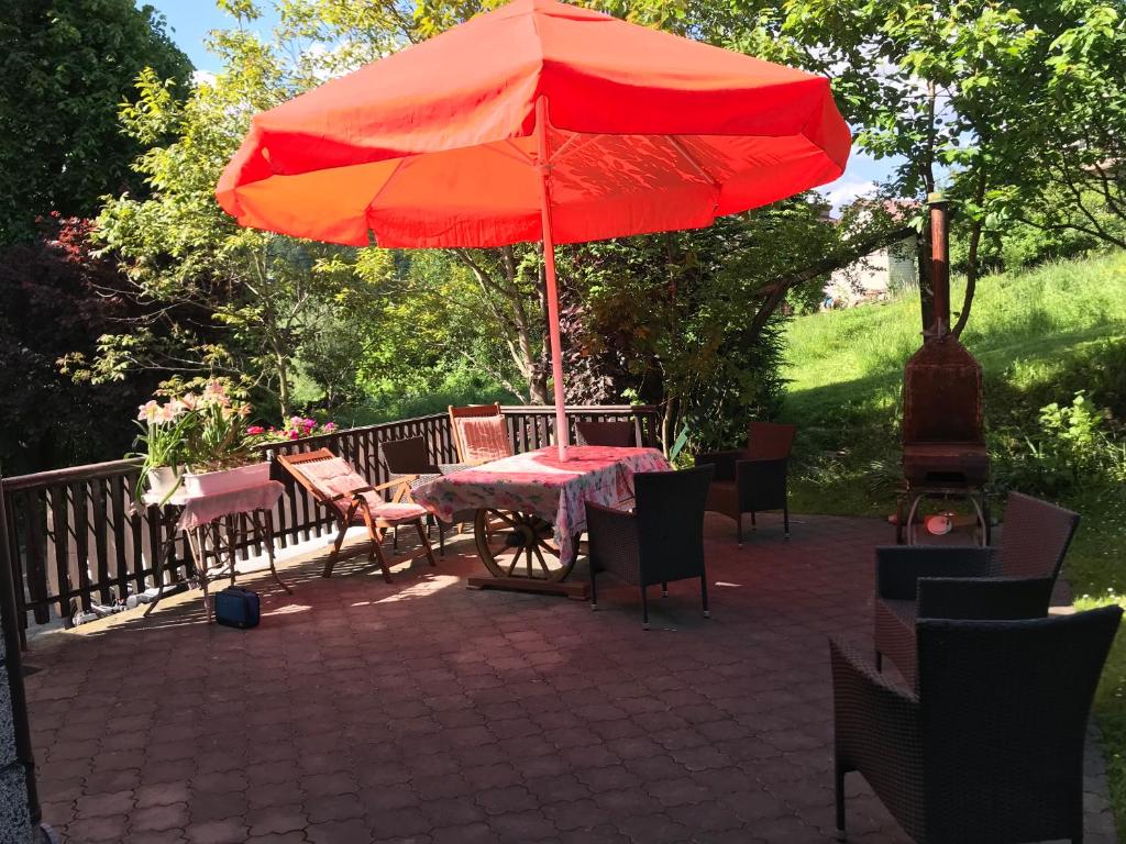 a table with a red umbrella on a patio at Apartament Roti Solina in Solina