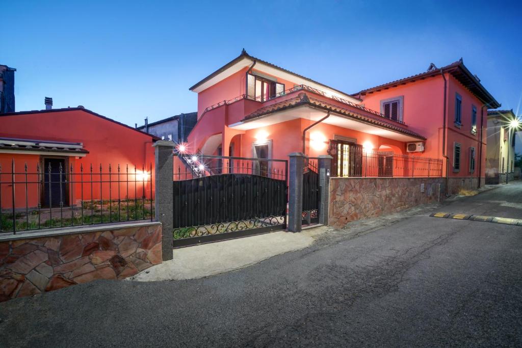 ein rotes Haus mit einem Tor auf einer Straße in der Unterkunft CASA VACANZE DA DANIELE in Marta