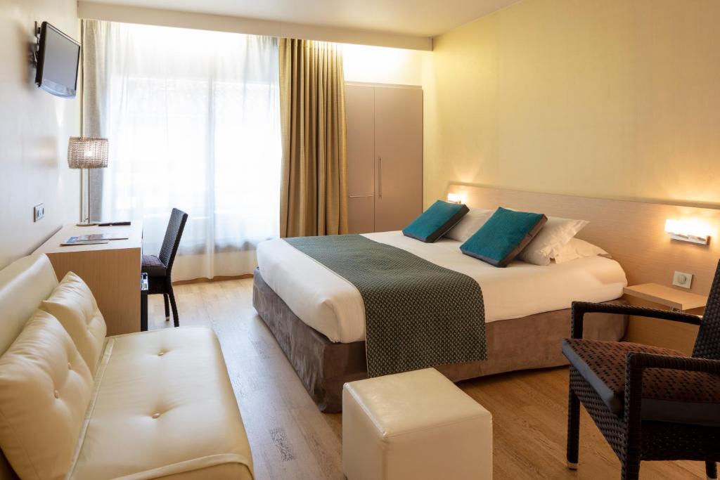 キヤンにあるHotel La Chaumièreのベッドとソファ付きのホテルルーム