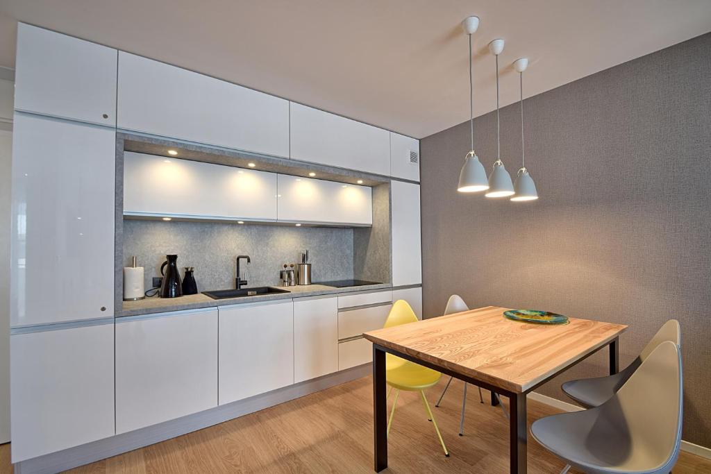 uma cozinha com uma mesa de madeira e cadeiras amarelas em Apartament PIER 72 PREMIUM em Kolobrzeg