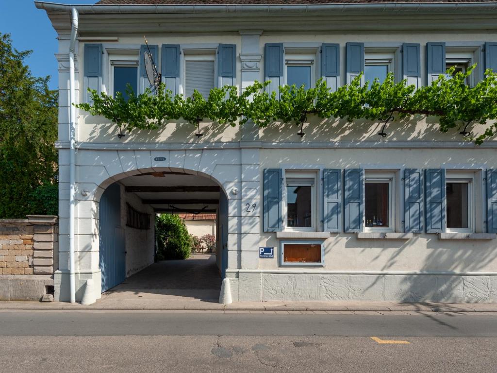 un edificio azul y blanco con un túnel en Gästezimmer im Weingut Wolf en Großkarlbach