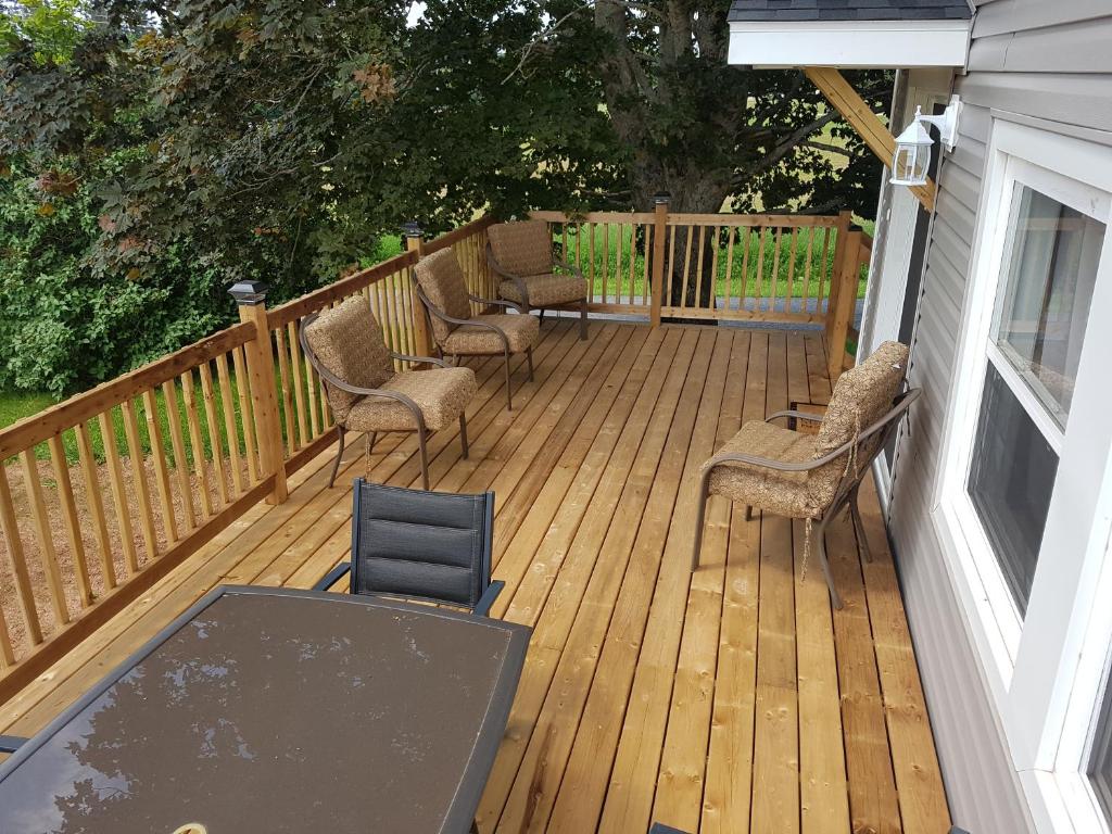 a wooden deck with chairs and a table on it at Small Town Bound Inn in Montague