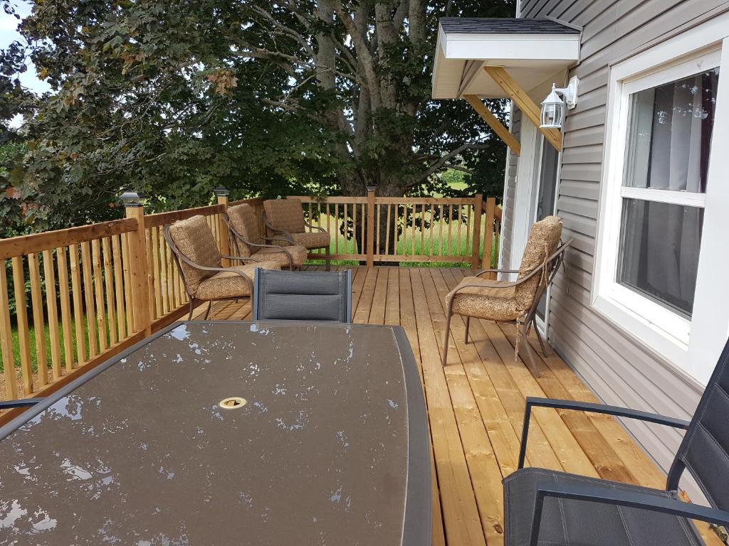 a patio with a table and chairs on a deck at Small Town Bound Inn in Montague