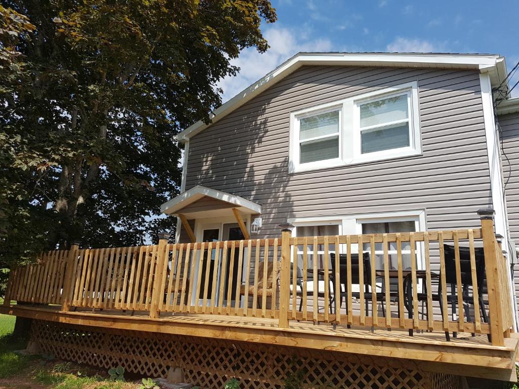 a house with a wooden deck with a dog on it at Small Town Bound Inn in Montague