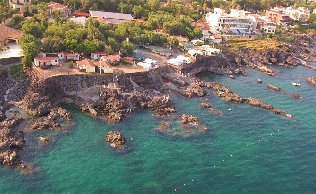 eine Luftansicht auf einen Strand mit Felsen im Wasser in der Unterkunft Camping Jonio in Catania