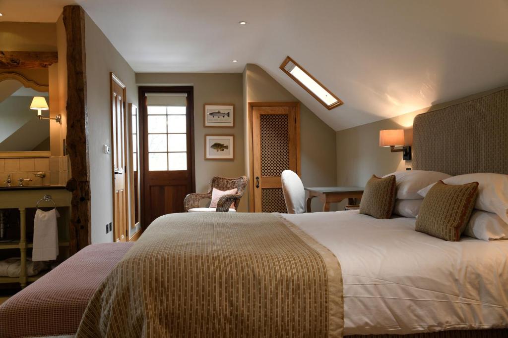 a hotel room with a large bed and a desk at The Bell at Ramsbury in Marlborough