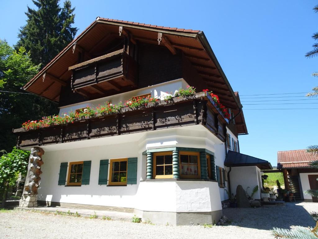 una casa con un balcón con flores. en Villa im Wald, en Rosshaupten