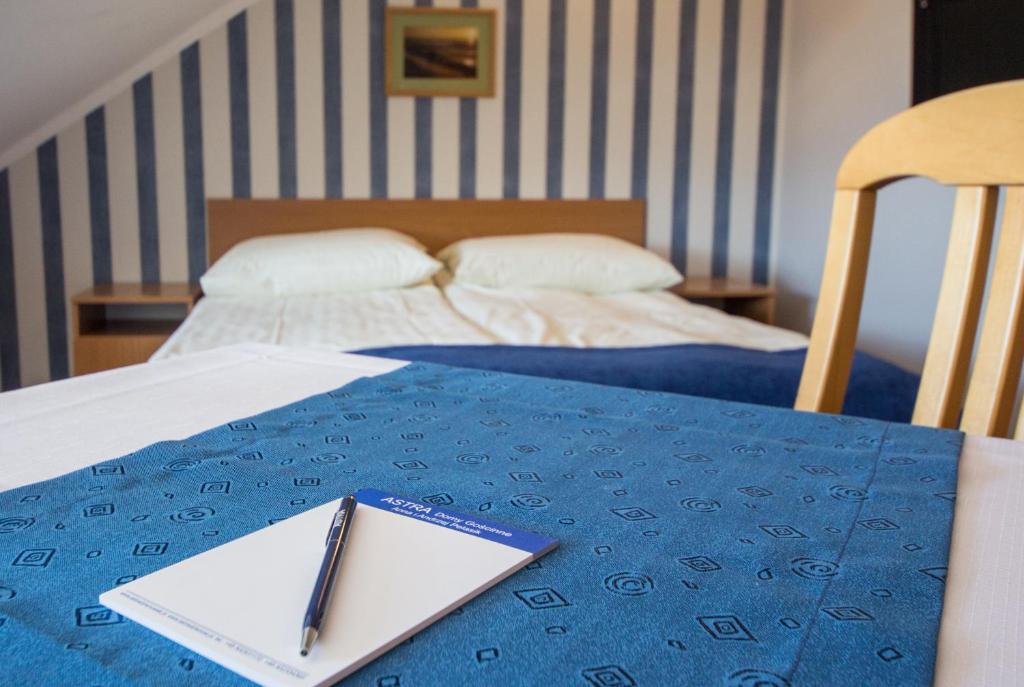 a table with a notebook and a pen on top of a bed at ASTRA DZIWNÓW in Dziwnów