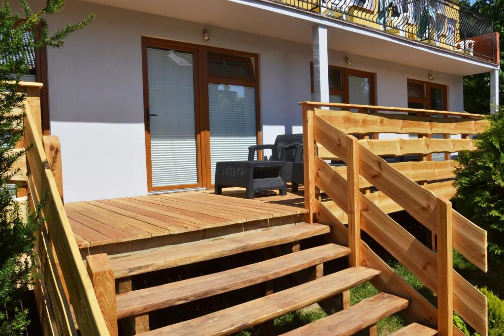 Pokoje Gościnne Bartek في ياستراوبيا جورا: سطح خشبي مع سلالم تؤدي إلى المنزل