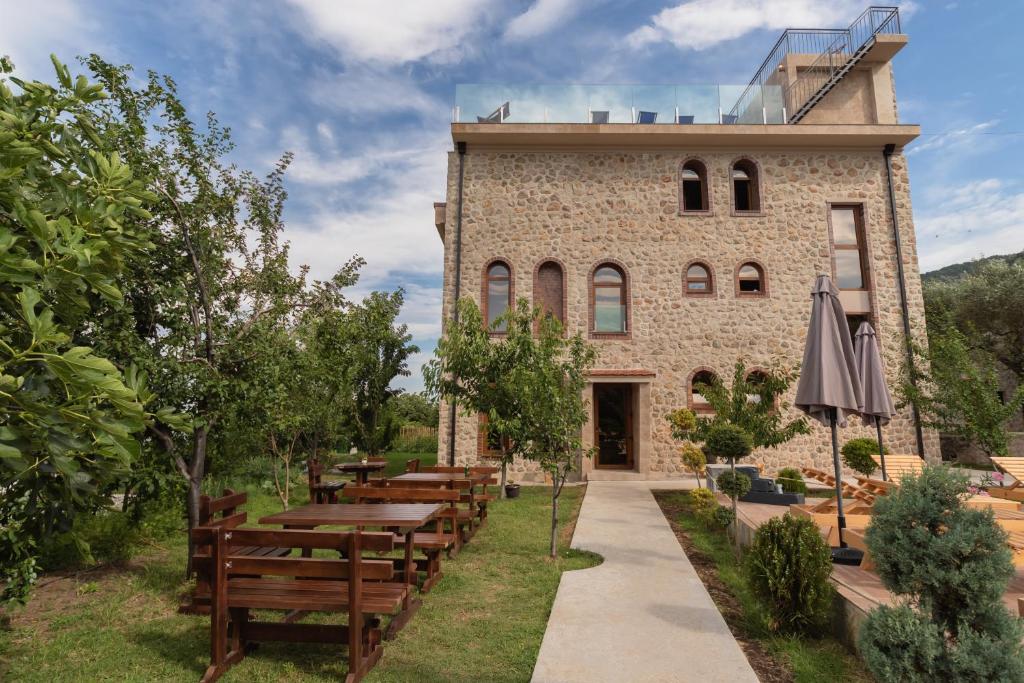 ein Gebäude mit Tischen und Bänken davor in der Unterkunft Apart & Spa Beganovic in Dobra Voda