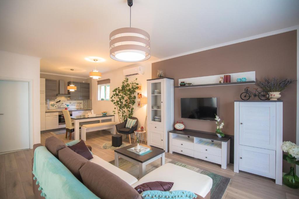 un salon avec un canapé et une télévision dans l'établissement Apartman Luna, à Šibenik