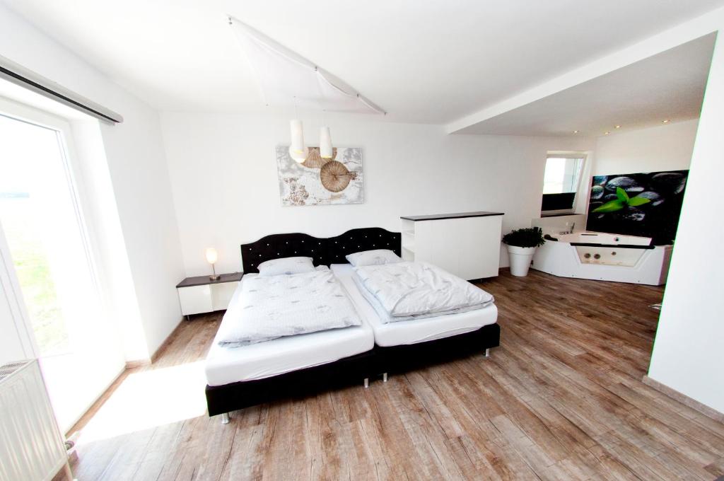 um quarto com uma cama num quarto com pisos em madeira em Gasthof Alpenblick em Sierning
