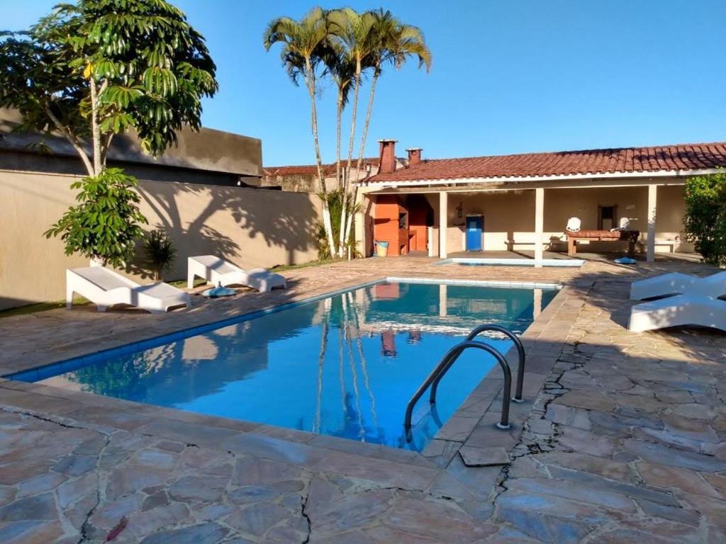 a swimming pool in a yard with a house at Associação Sabesp Ilha Comprida in Ilha Comprida