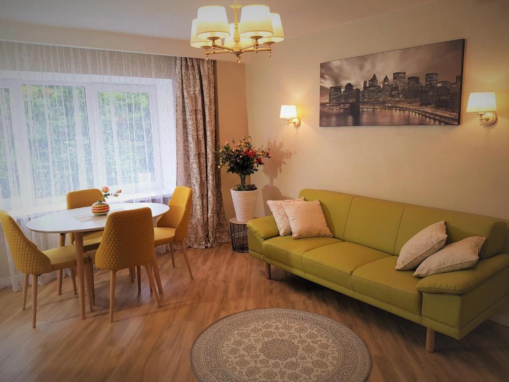 uma sala de estar com um sofá verde e uma mesa em TIP TOP em Siauliai