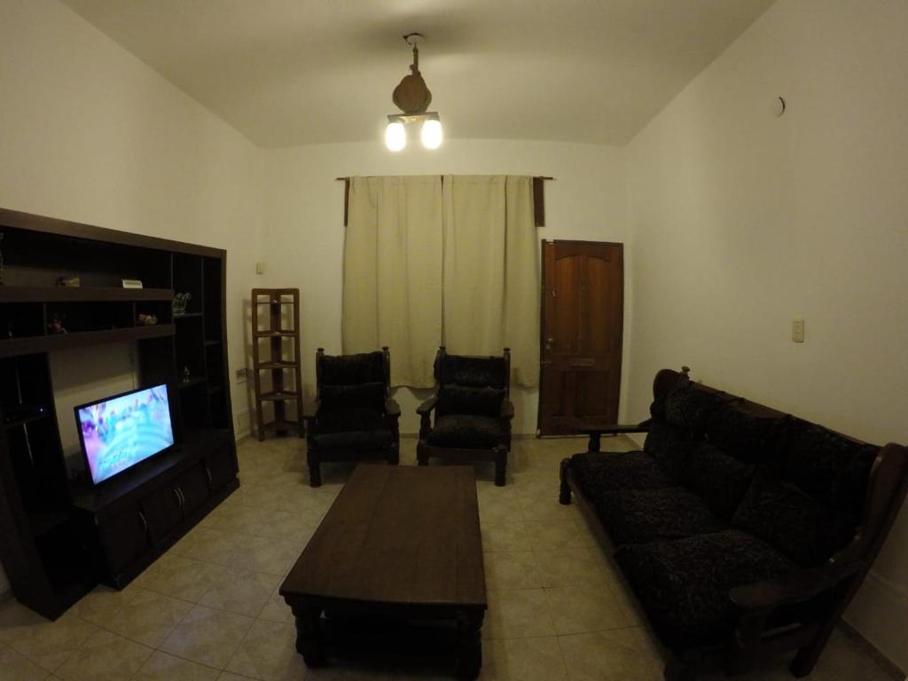 a living room with a couch and a tv and chairs at Casa, hogar equipado para el viajero y su familia. in Cordoba