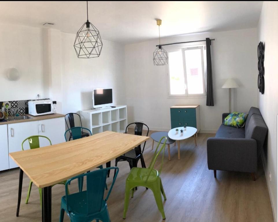 a kitchen and living room with a table and chairs at Maison design perros guirec, 2 à 4 personnes in Perros-Guirec