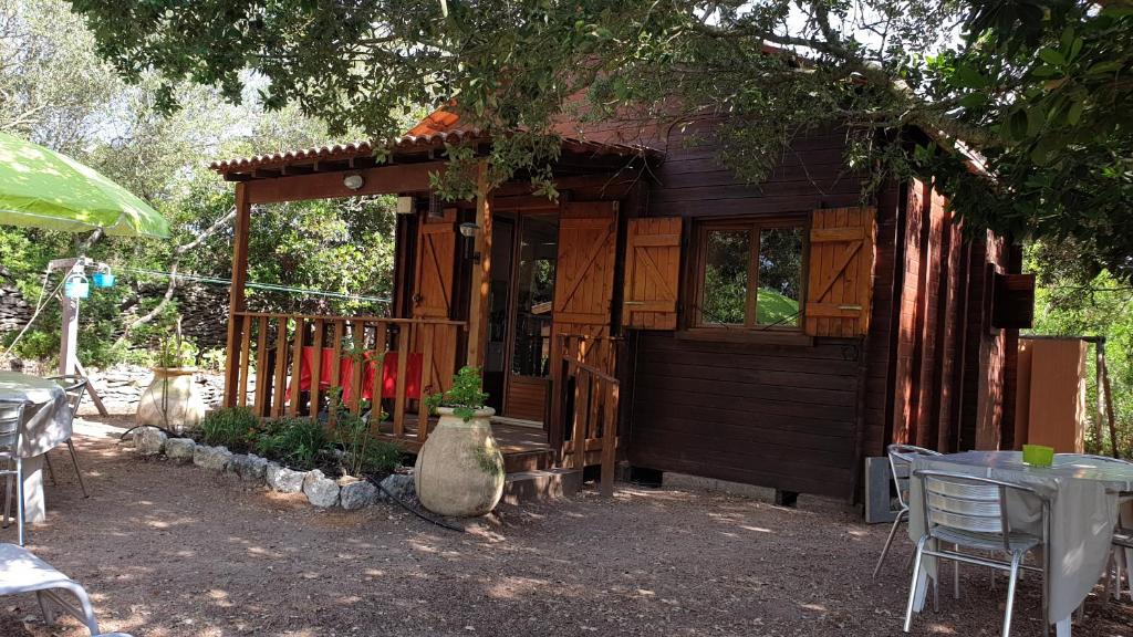 a small wooden cabin with a table and chairs at chalet Bati in Bonifacio