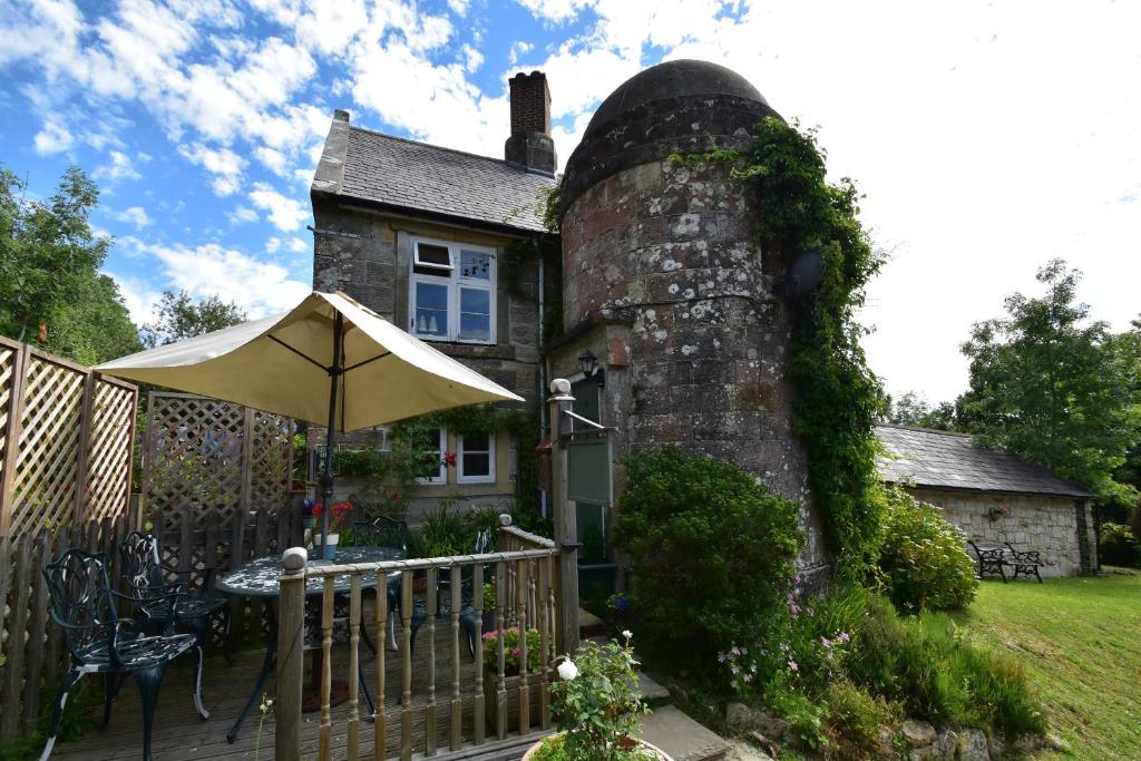 een huis met een paraplu en een tafel met een paraplu bij Little Turret in St. Leonards